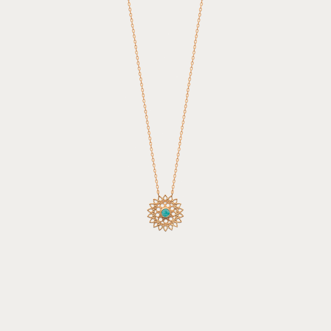 Le magnifique collier chaîne forçat fine avec un pendentif rond en forme de soleil avec une pierre naturelle Amazonite au centre.