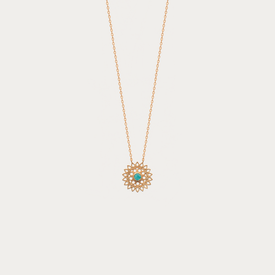 Le magnifique collier chaîne forçat fine avec un pendentif rond en forme de soleil avec une pierre naturelle Amazonite au centre.