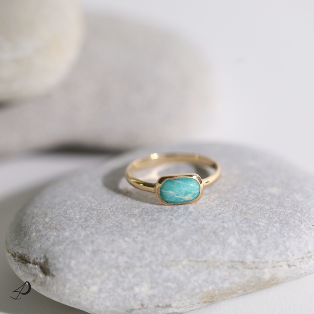 Découvrez notre collection Aspen qui comporte une bague avec anneau fin plaqué or jaune et un pendentif avec une pierre naturelle Amazonite de couleur vert, blanc et turquoise au centre de la bague Aspen.