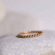 Une jolie petite bague simple avec quelques petites boules rondes sur tous l'ensemble de l'anneau de la collection Coronado.