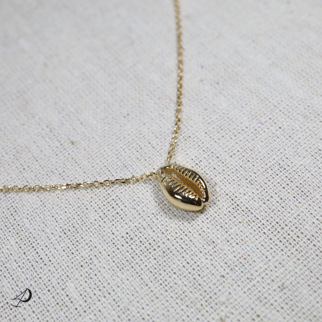 Ce magnifique collier avec un pendentif soudé à la chaîne est en forme de coquillage cauris, parfait pour cet été !